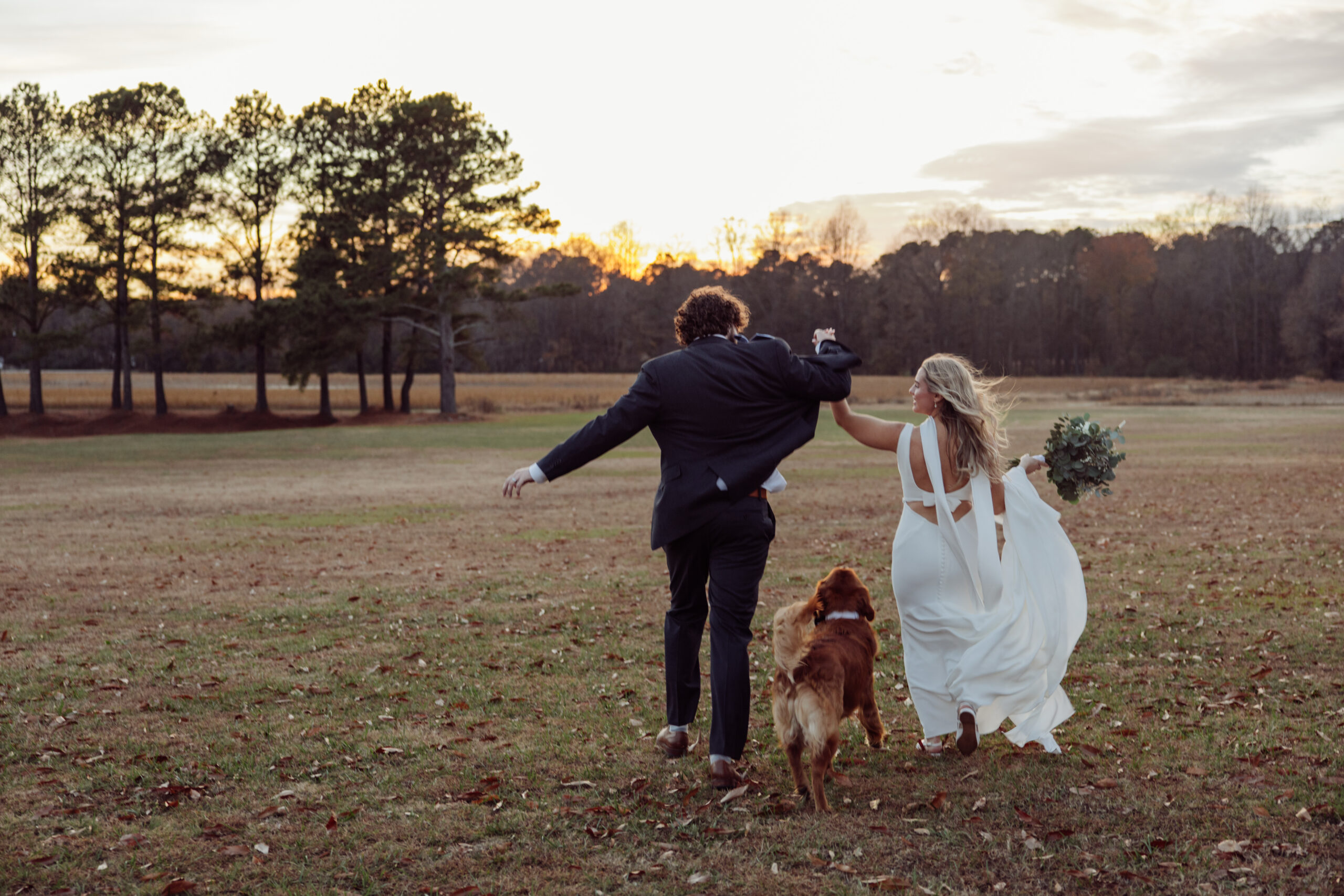 Couple running away with dog
