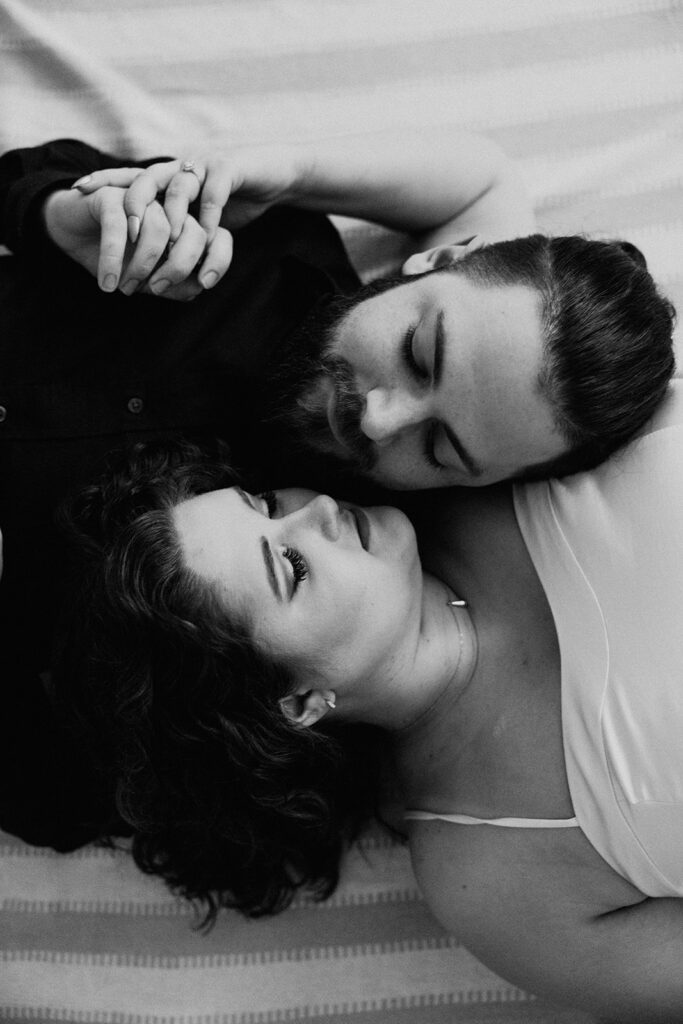 black and white couple's photo, couple laying down, engagements, holding hands